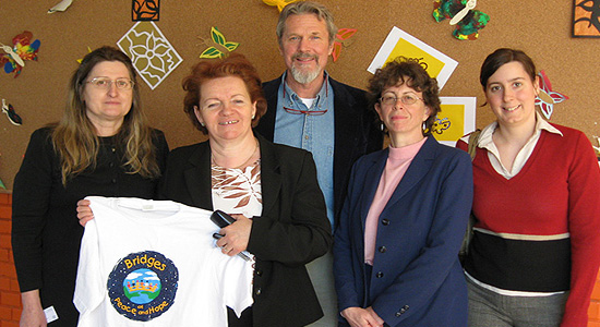 US Embassy  Cultural Attache Carolyn Glassman (2nd from Right) and assistant Monika  Vali (far right) join John Farrell in presenting BoPH tee shirt to  administrators at Kolozsvar School in Budapest.